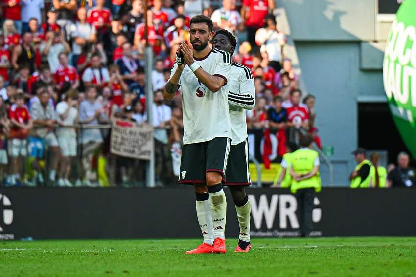 Gelandang sekaligus kapten Manchester United Bruno Fernandes mengenakan jersey utama klub saat memimpin rekan setimnya di lapangan.