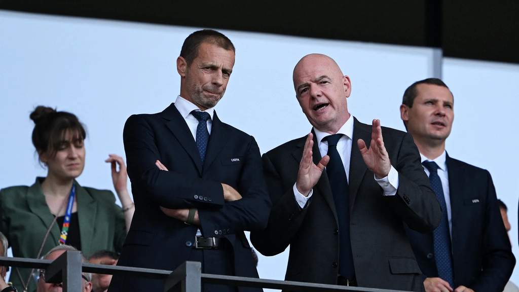 Presiden FIFA Gianni Infantino tampak berbicara dalam sebuah konferensi pers di hadapan para awak media internasional dengan latar belakang bendera organisasi.