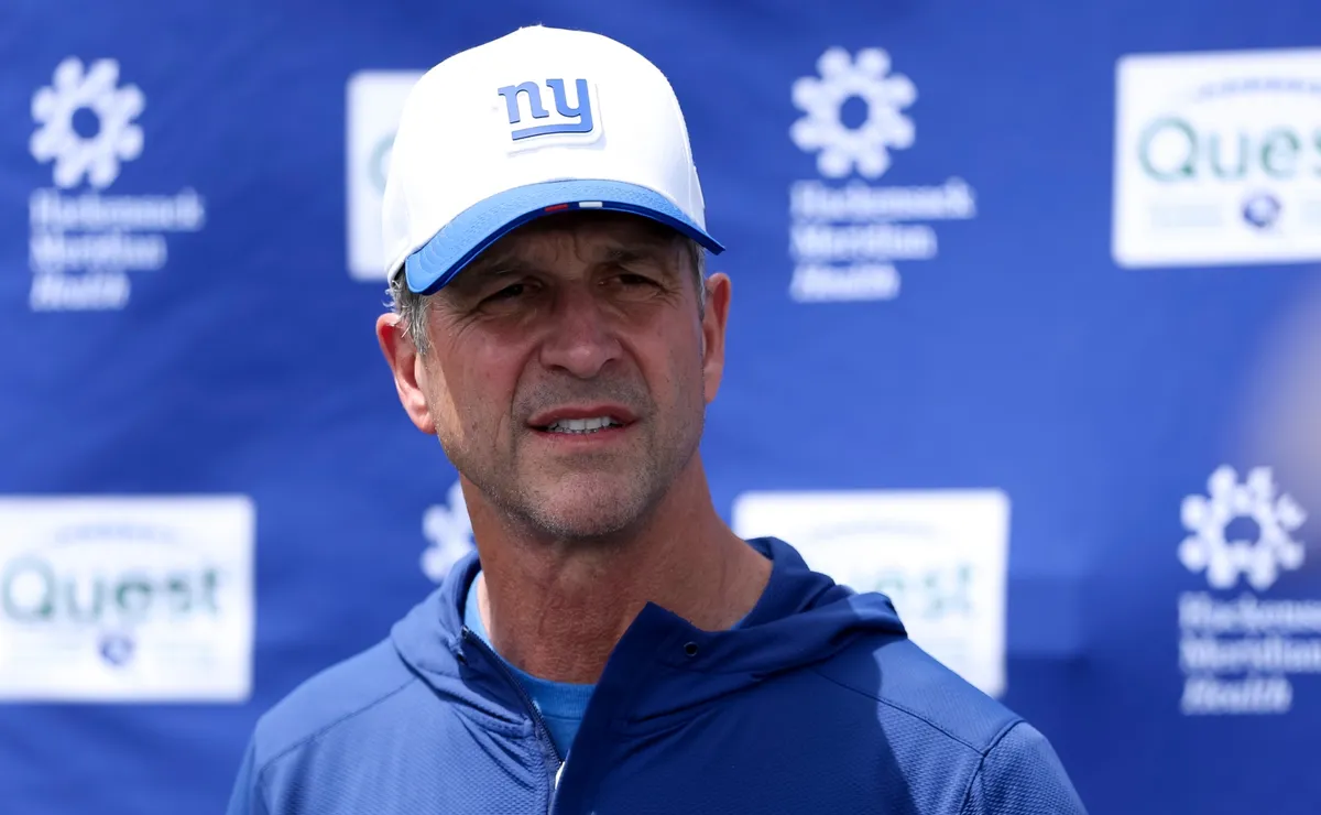 Pelatih kepala John Harbaugh memberikan arahan di pinggir lapangan kepada para pemain New York Giants dalam sesi latihan pramusim.
