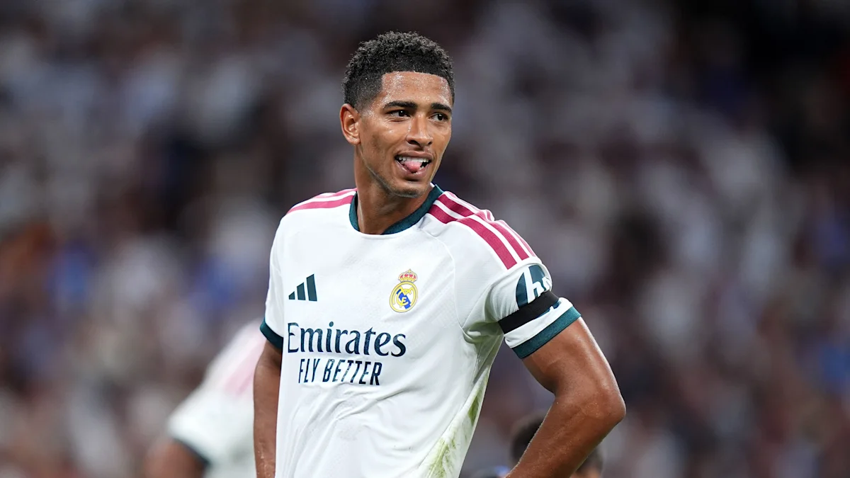 Pemain gelandang Real Madrid Jude Bellingham melakukan selebrasi di lapangan stadion Santiago Bernabeu mengenakan jersey putih klub.