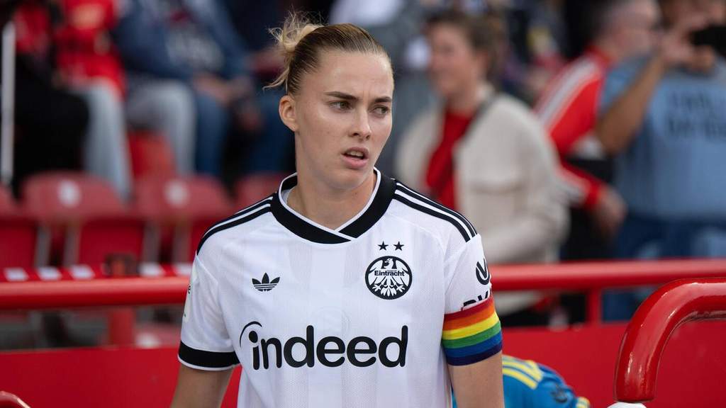 Laura Freigang merayakan gol kemenangan untuk Eintracht Frankfurt dengan mengangkat tangan di lapangan hijau.