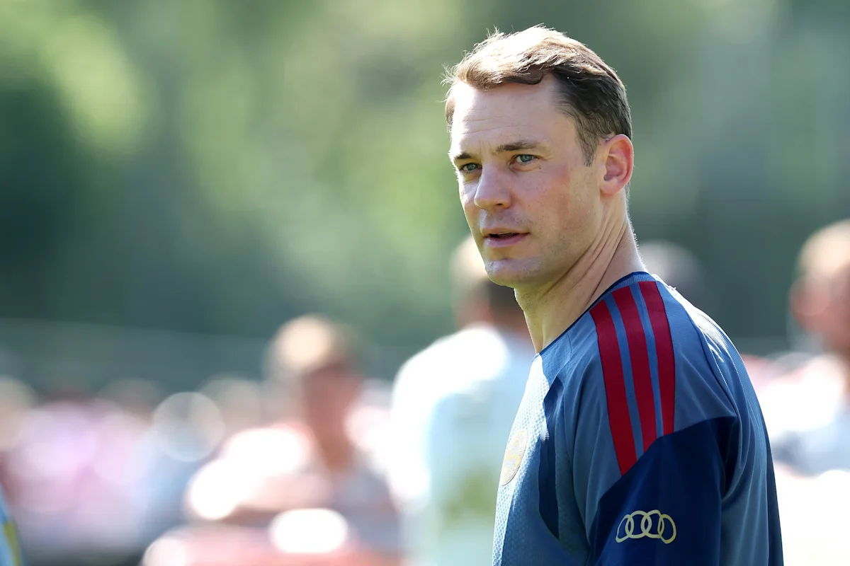 Kiper senior Bayern Munich Manuel Neuer sedang berdiri di bawah mistar gawang mengenakan jersey penjaga gawang klub.