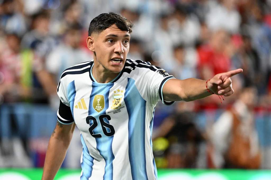 Pemain belakang tim nasional Argentina Nahuel Molina sedang berlari menggiring bola dalam sebuah pertandingan kompetitif di stadion.