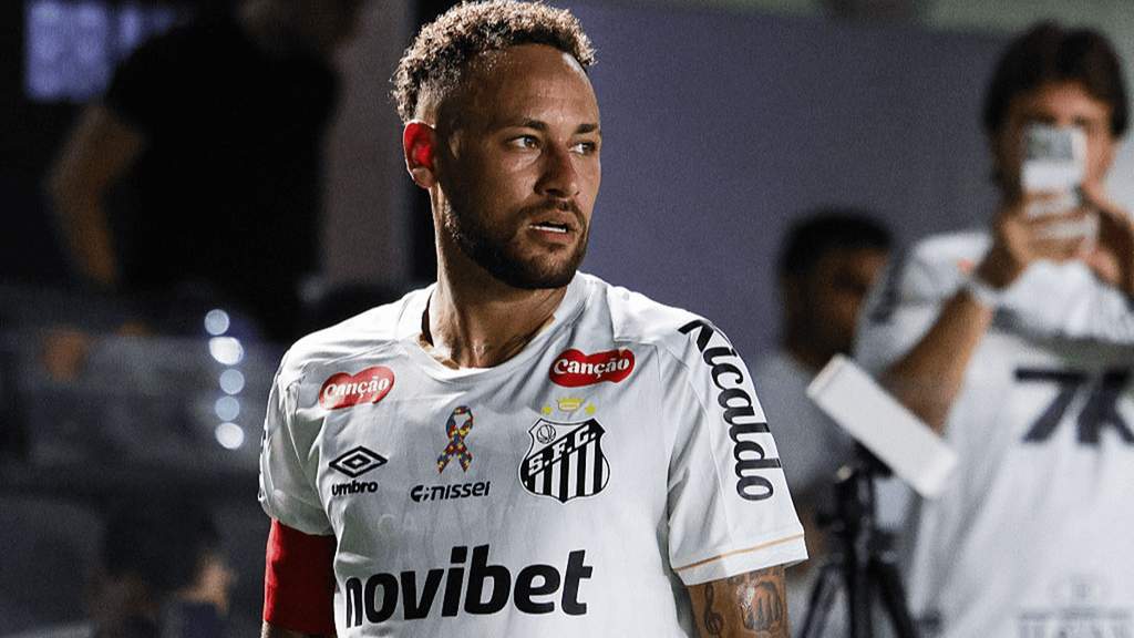 Penyerang bintang Brasil Neymar mengenakan jersey latihan klub Santos sambil tersenyum di pinggir lapangan latihan klub.