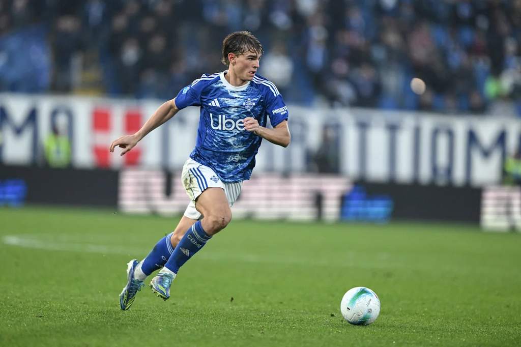 Nico Paz saat mengenakan seragam Como dalam pertandingan Serie A Liga Italia dengan latar penonton stadion.