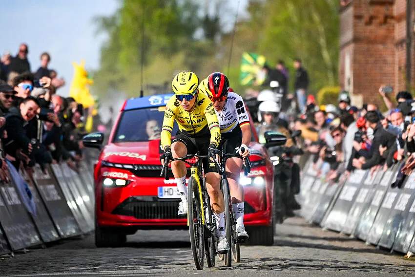 Pebalap sepeda Pauline Ferrand-Prévot saat memacu sepedanya di etape Tour de France Femmes dengan latar belakang pendukung di pinggir jalan.