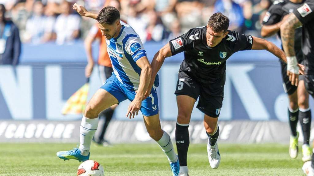 Para pemain Hertha BSC merayakan gol kemenangan di lapangan Olympiastadion disaksikan puluhan ribu suporter di tribun.