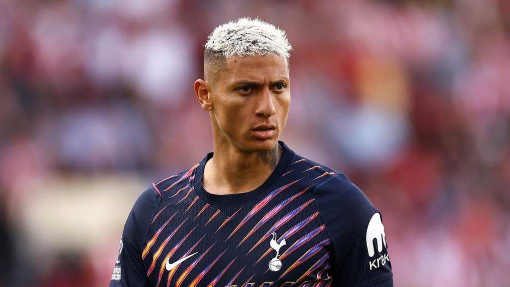 Penyerang Tottenham Hotspur Richarlison tampak berdiri di tepi lapangan mengenakan perlengkapan latihan klub London utara tersebut.